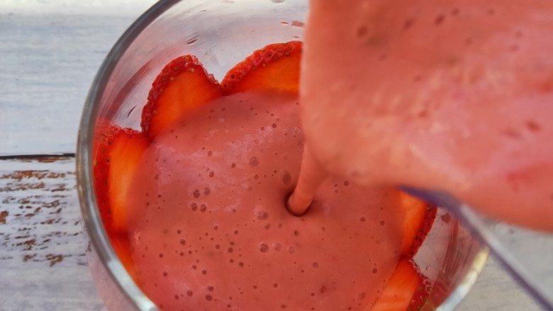 草莓酸奶昔,在把榨好的草莓奶昔倒入杯中