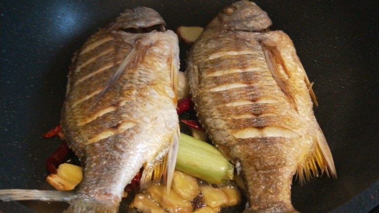 酱焖黄花鱼,鱼放入锅中。