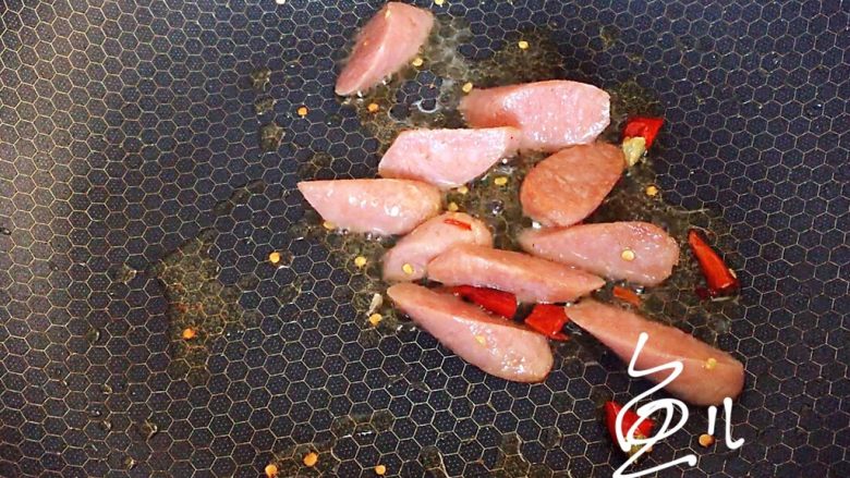 卷心菜炒粉丝,油锅烧热，放入干红辣椒和火腿肠翻炒片刻