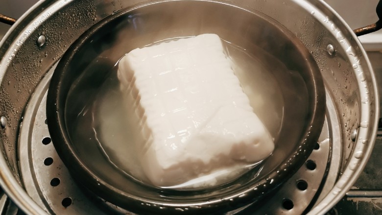 鳕鱼炖豆腐,豆腐从盒子里取出  上蒸锅蒸10分钟 取出切块 备用