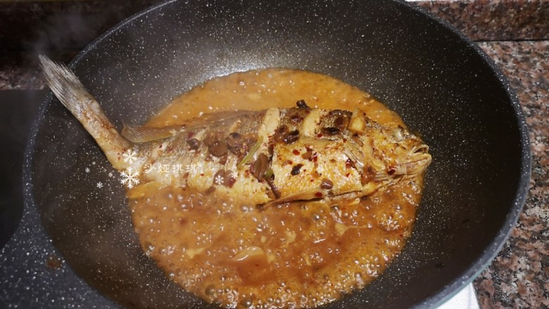 酱焖黄花鱼,汤汁收干一半时再将鱼翻面煮。