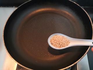 自做豌豆凉粉,在等粉糊凝固的过程中，上锅，把芝麻倒入锅中