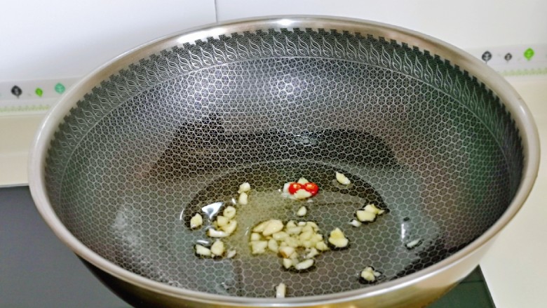 卷心菜炒粉丝,起油锅，加入蒜和辣椒炒香。