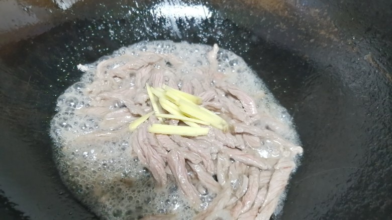 牛肉丝炒芹菜,牛肉表面全部变色，加入姜丝，继续翻炒。
