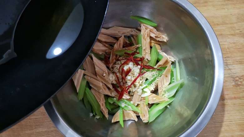 芹菜拌腐竹,将热油浇在各种食材上，滋啦一声后，香味全都激发出来了，拌匀即可。