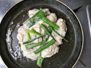 牡蛎炒蛋,摊平，煎一会，放入葱段。
