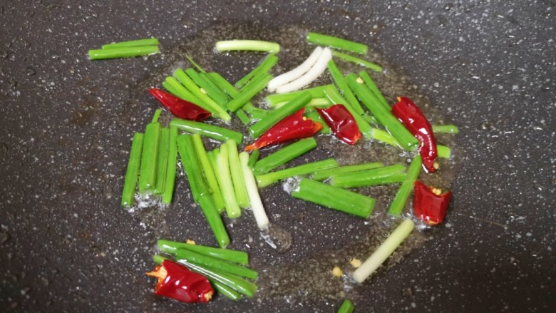 芹菜炒木耳,炒锅内继续倒油烧热，下入葱段和干红辣椒爆香。
