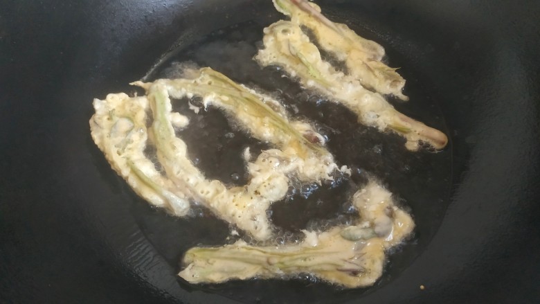 炸香椿鱼,锅中放入适量植物油，放入裹满面糊的香椿