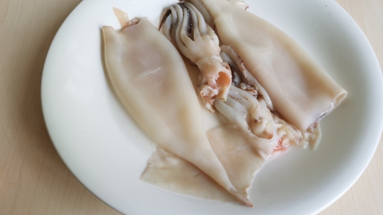 鱿鱼炒芹菜,然后把鱿鱼身体表面的黑膜撕掉，冲洗干净后的鱿鱼就变得白白净净了。
