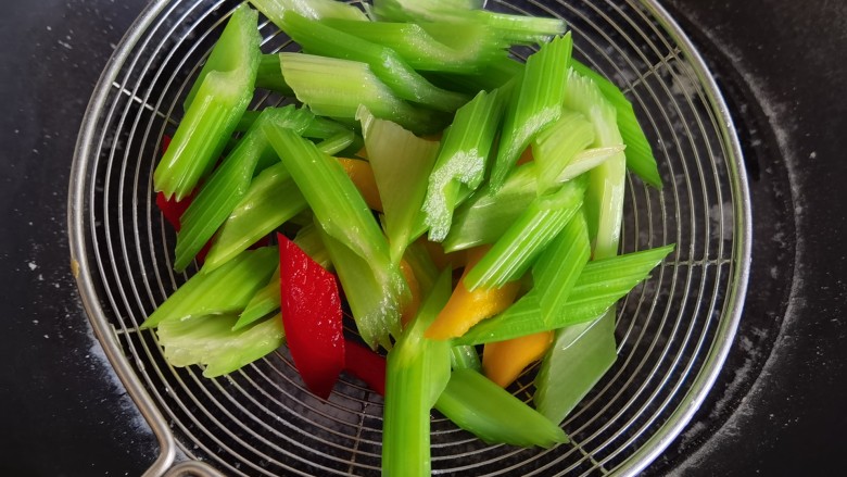 鱿鱼炒芹菜,将切好的芹菜和红黄椒一起焯水，捞出过凉水，控水备用。。