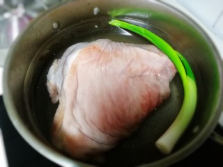 酱肘子,加一根葱冷水放入肘子，煮至水滚开。