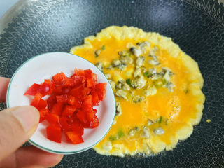 牡蛎炒蛋,待鸡蛋液表面凝固放入红椒丁