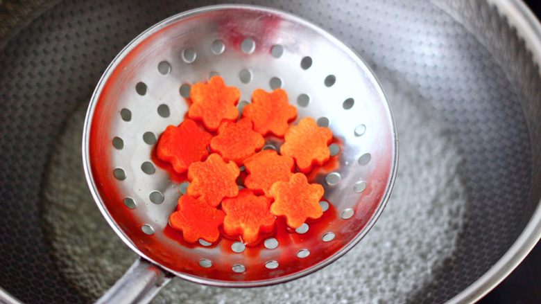 酱焖黄花鱼,锅中倒入适量的清水烧开，加入胡萝卜焯一下水，看见胡萝卜变软捞出沥干水分。