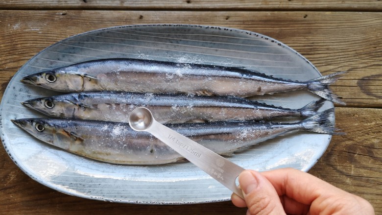 干煎秋刀鱼,在秋刀鱼的两面撒少量的盐搓匀。