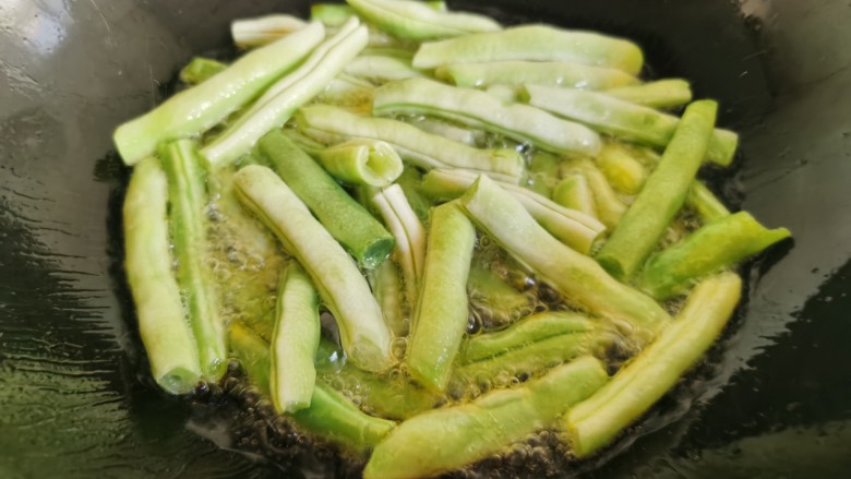 干煸芸豆,锅里放入多一点的油，放入芸豆段炸熟。