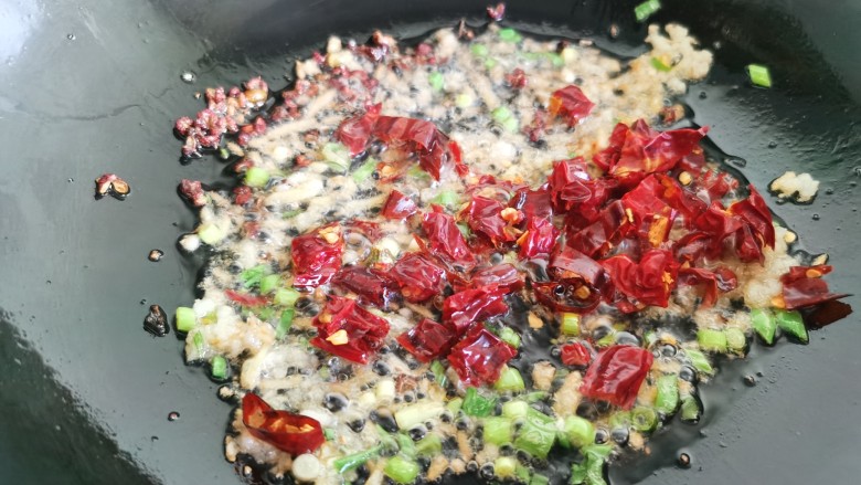 干煸芸豆,锅里留一些底油，放入干辣椒，花椒，葱、姜、蒜爆香。
