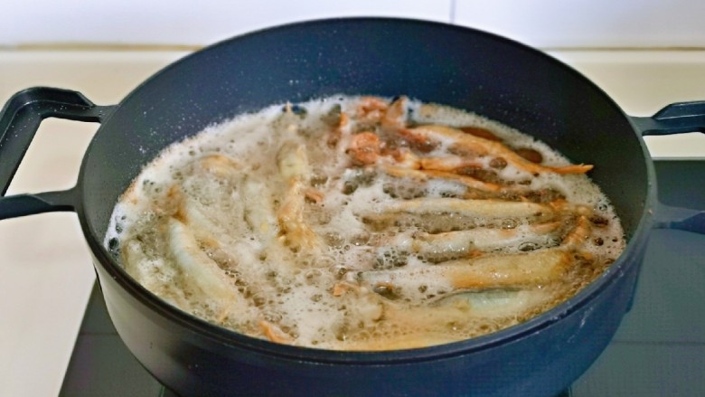 酥炸多春鱼,起油锅，油温6成热时加入裹好的面粉的鱼。