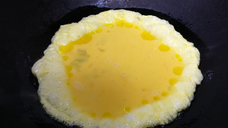 青椒腊肠炒蛋,油温六分热倒入蛋液。