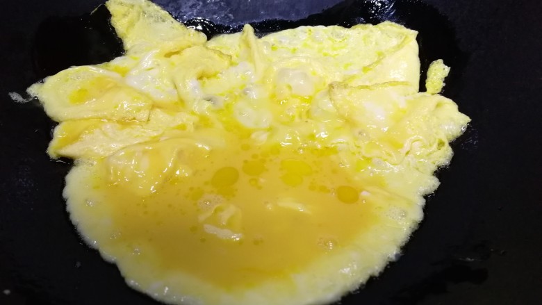 青椒腊肠炒蛋,周围熟的鸡蛋推到锅边，把中间的蛋液摊熟。