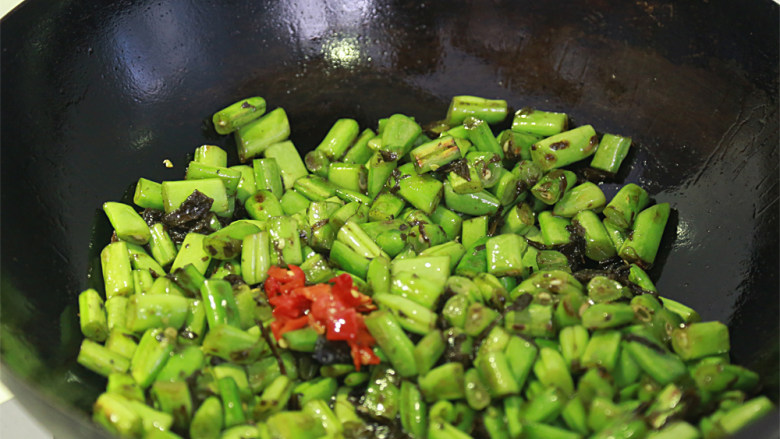 橄榄菜炒四季豆,倒入剁椒，继续炒熟炒匀加盐调味出锅。