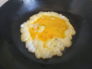大头菜蛋炒饭,锅中放入适量植物油。放入蛋液煎至凝固成形