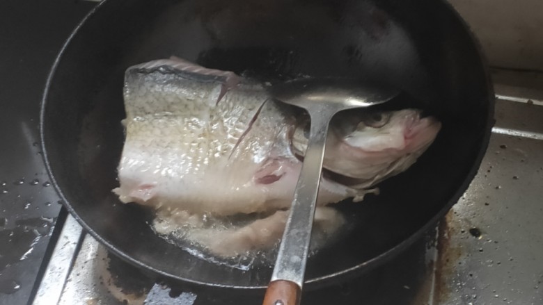 酸菜鱼头火锅,起锅放油，油烧开放入鱼头，