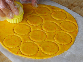 胡萝卜饼干,用模具压出花形，边角料可以继续揉捏在一起后继续擀薄片压出花形。