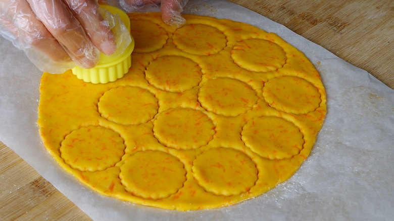 胡萝卜饼干,用模具压出花形，边角料可以继续揉捏在一起后继续擀薄片压出花形。