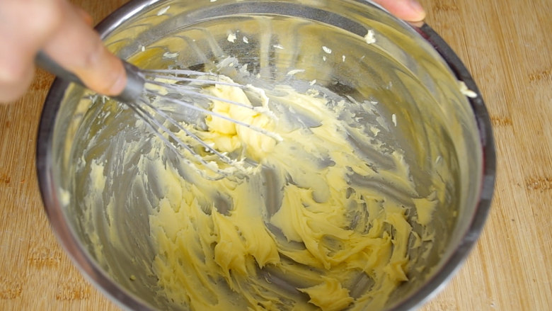 胡萝卜饼干,搅拌至黄油与糖粉完全融合后，用蛋抽把黄油搅打至蓬松状，也可以使用打蛋器，因为量少，也为了减少清洗的工作所以就没有动用打蛋器。