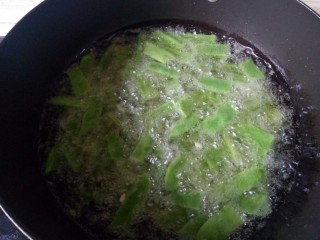 干煸芸豆,锅中加入适量油烧至五层热，炸至芸豆表面有虎皮皱