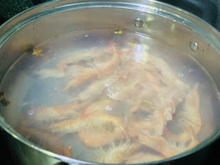 明虾鸡爪煲,锅里加水，加姜片，加料酒，煮沸，加明虾焯水；