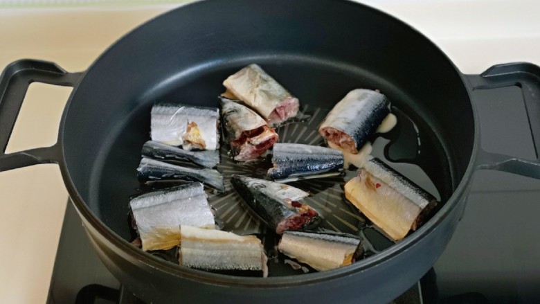 红烧秋刀鱼,起油锅，加入鱼段小火煎。