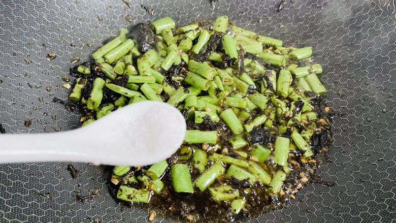 橄榄菜炒四季豆,加入适量的盐翻炒均匀