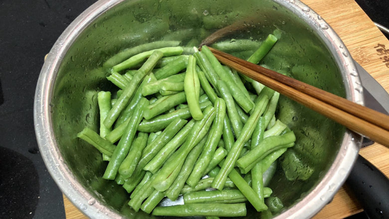 干煸芸豆➕枝间新绿一重重,捞出过凉水，沥水备用。焯水后豆角更容易熟可以减少煎炸的时间。