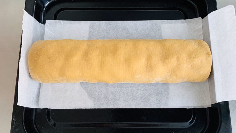 咖啡列巴,烤盘铺上油纸，卷好的面包放在烤盘上。长帝CRDF32WBL烤箱发酵功能，进行二次发酵30分钟。发酵的时候下面放一盘沸水，保持面包的湿度。
