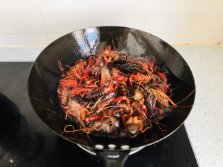蒜香小龙虾,锅内倒入适量食用油，把小龙虾倒入油锅中过油炸一遍，颜色变红后关火。