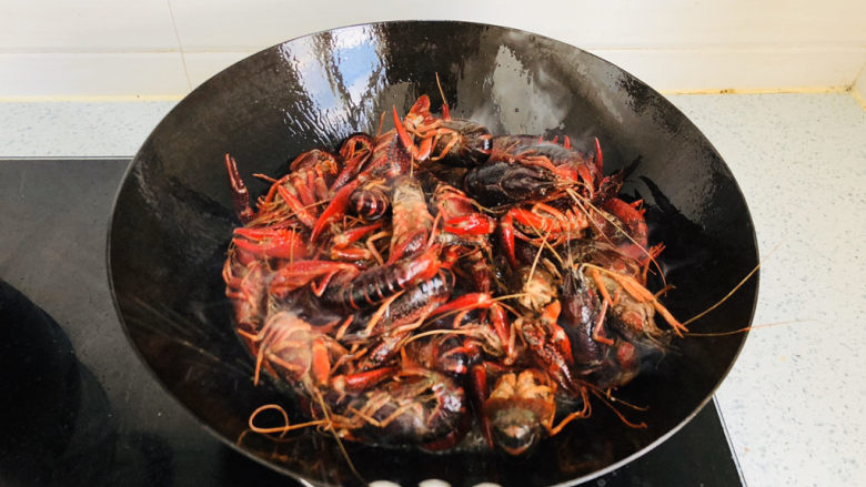 蒜香小龙虾,锅内倒入适量食用油，把小龙虾倒入油锅中过油炸一遍，颜色变红后关火。