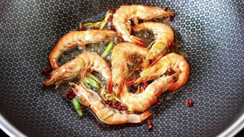 西葫芦炒木耳,看见海虾两面煎出虾油，盛出备用，把锅中花椒和葱姜捞出不用。