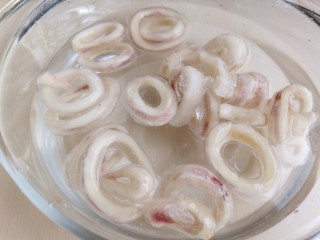 黄金鱿鱼圈,冷冻的鱿鱼圈加水解冻。如果是鲜鱿鱼，要把内脏去除，然后把鱿鱼表面的黑膜撕掉，切成鱿鱼圈即可。