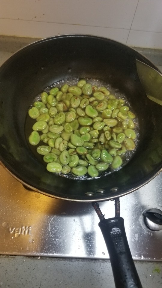葱油蚕豆,翻炒3~4分钟后，加水，盖盖儿焖煮。