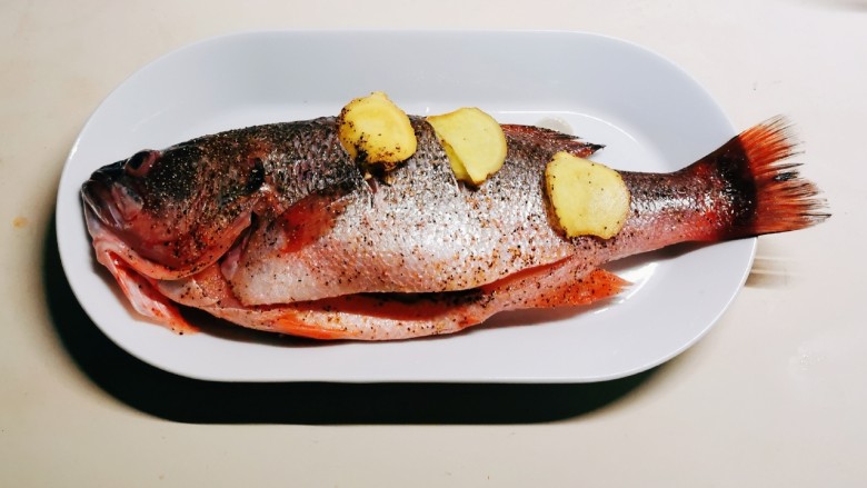 葱油鲈鱼,放上腌好的鱼 将剩下的葱片放入鱼肚子里