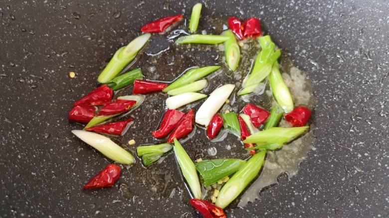 山药炒肉片,锅底留余油，下入小葱和干红辣椒炒香。