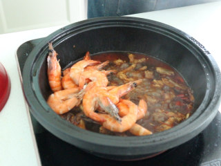 明虾鸡爪煲,放入虾，翻搅入味，盖上锅盖继续焖炖几分钟