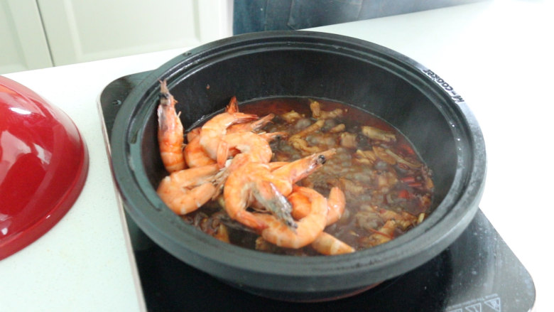 明虾鸡爪煲,放入虾，翻搅入味，盖上锅盖继续焖炖几分钟