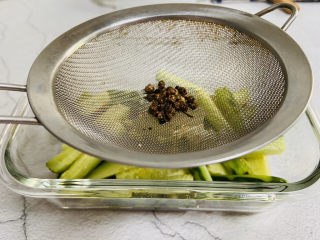 酸辣黄瓜条-开胃小菜,取一滤网将热油倒入容器内