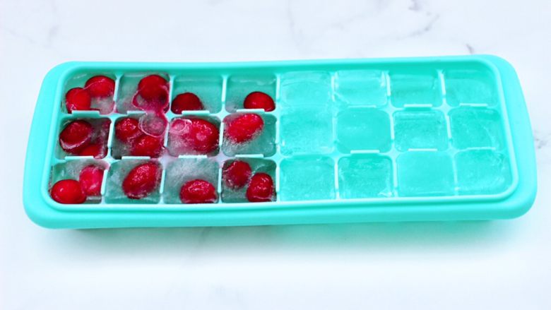蔓越莓桑葚气泡水,把一半的蔓越莓果清洗后，放入冰格里，加入纯净水，放入冰箱冷冻。