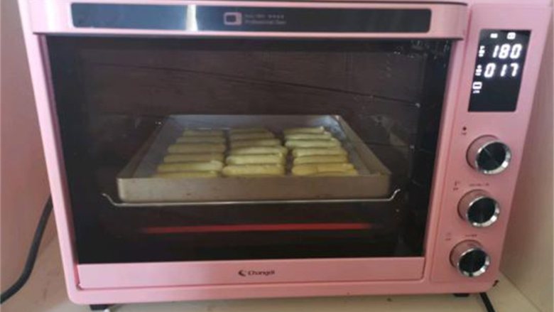 手指饼干,把烤盘放入提前预热好的烤箱，上下火180度烤18分钟左右即可。