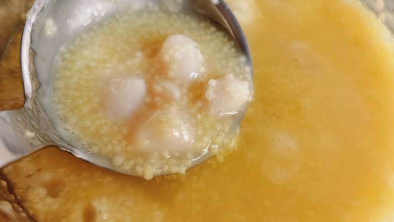 小米海参粥,当小米粥煮至粘稠时，加入鲜贝和一片生姜。