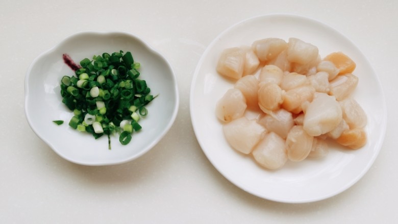 小米海参粥,鲜贝用水冲洗一下，如果用干贝，需要提前用水泡发。再切少许葱姜。
