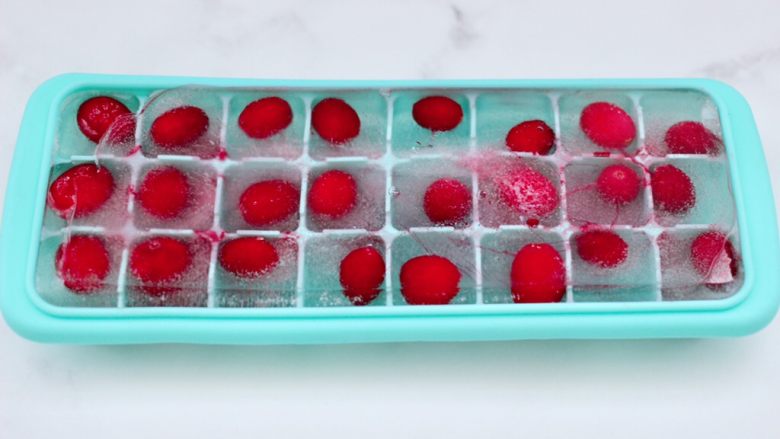 自制蔓越莓冰酸奶（内附酸奶做法）,把蔓越莓果清洗后，放入冰格里，加入纯净水，放入冰箱冷冻。